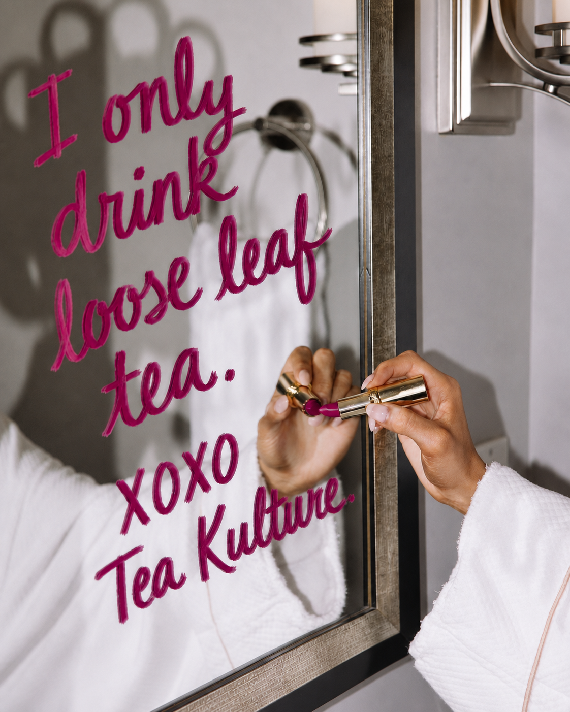 Hand writing 'I only drink loose leaf tea xoxo Tea Kulture' on a mirror in lipstick